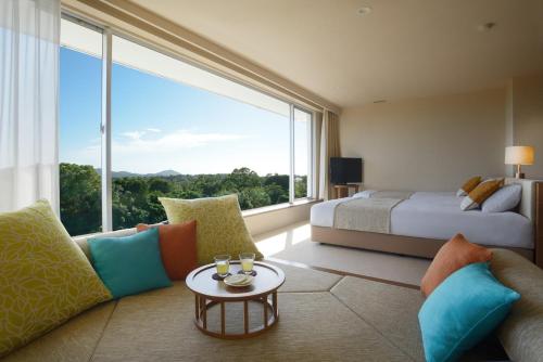 a hotel room with a bed and a large window at Nemu Resort Hotel Nemu in Shima