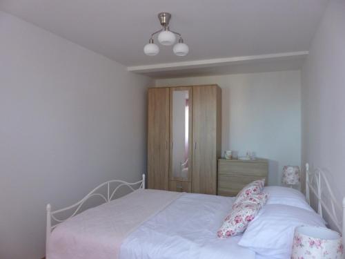 a bedroom with a white bed and a wooden cabinet at Aničić in Opatija