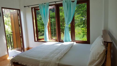 ein Schlafzimmer mit einem Bett und einem großen Fenster in der Unterkunft Sanfhan Resort-SHA Plus in Khao Chai Son