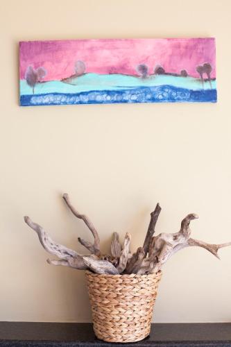 a plant in a basket next to a painting at Kamiros Apartment in Kalavárda
