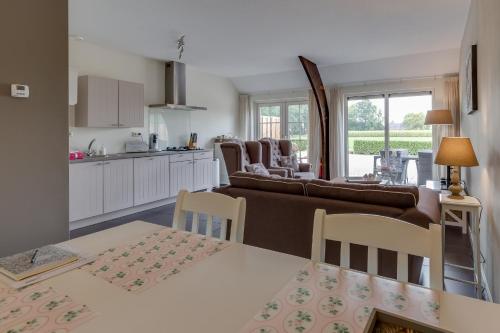 cocina y sala de estar con sofá y mesa en B&B vakantieappartementen Dalerheugte, en Dalerveen