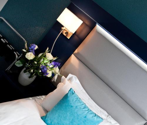 a bedroom with a pillow and a vase of flowers at Prince Albert Montmartre in Paris