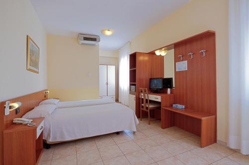 Hotel Mary في لا سبيتسيا: غرفة نوم مع سرير ومكتب مع جهاز كمبيوتر