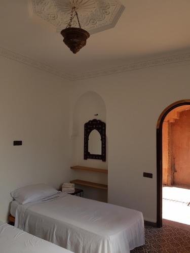 a bedroom with two beds and a window and a ceiling at Atlas Resorts in Aït Ourir