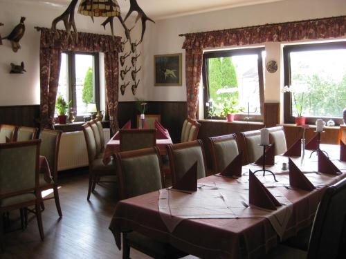 ein Esszimmer mit Tischen, Stühlen und Fenstern in der Unterkunft Wirtshaus zum Wilddieb in Bad Rappenau