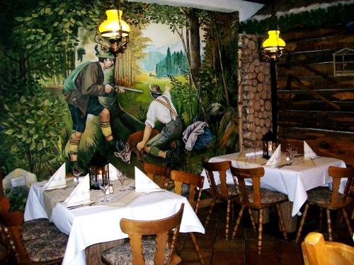 バート・ラッペナウにあるWirtshaus zum Wilddiebの壁画が飾られたテーブル2台のレストラン