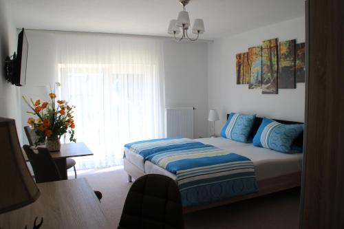 ein Schlafzimmer mit einem Bett mit blauen Kissen und einem Fenster in der Unterkunft Wirtshaus zum Wilddieb in Bad Rappenau