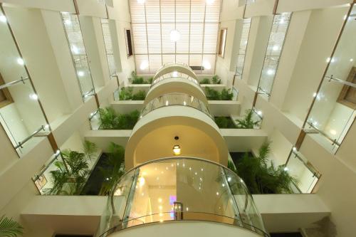 a large building with escalators and plants in it at Sidra Pristine Hotel and Portico Halls in Cochin