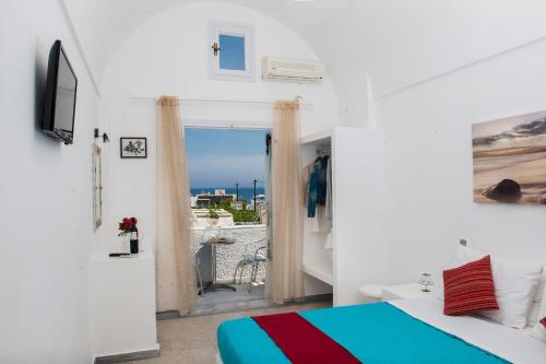 a bedroom with a bed and a view of the ocean at Join Us Low Cost Rooms in Kamari