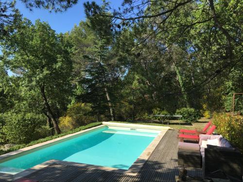 einen Pool mit einer Terrasse, Stühlen und Bäumen in der Unterkunft Villa de Carbonelle in Pierrevert