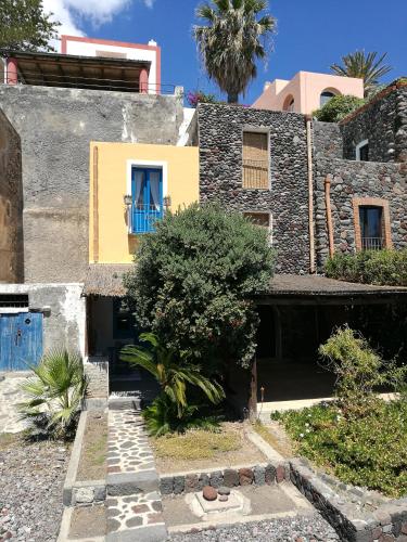 a house with a blue door and a tree at La Casa di Via Lungomare in Santa Marina Salina