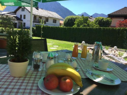 a table with a plate of fruit on it at Hotel-Restaurant Bellevue in Ruhpolding