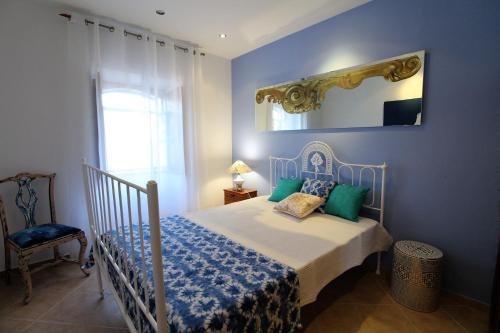 um quarto azul com uma cama e um espelho em Casa Rocha em Albufeira