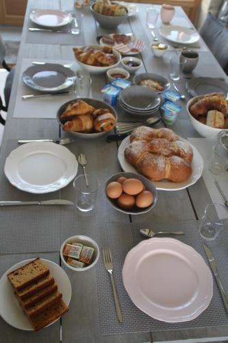 Una mesa cubierta con platos y cuencos de comida en B&B Fleur de Lys Bleue, en Soudaine-Lavinadière