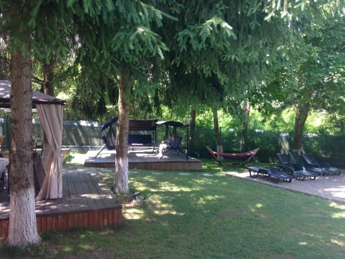 a person sitting in a hammock under some trees at Hotel Diana in Geoagiu Băi
