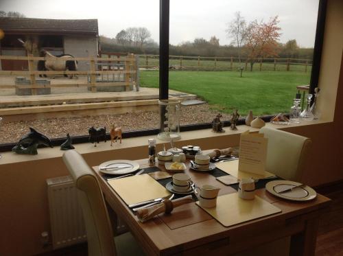 a dining room table with a view of a field at Ravencar Farm B&B in Eckington