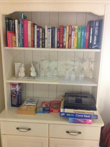 a book shelf filled with glasses and books at Ravencar Farm B&B in Eckington