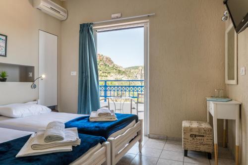 1 dormitorio con 2 camas y ventana grande en Argyro Rent Rooms en Kritsá