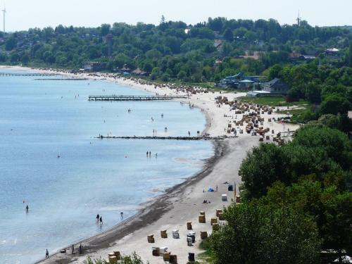 a beach with a bunch of people in the water at Apartment Lütte Bris in Eckernförde