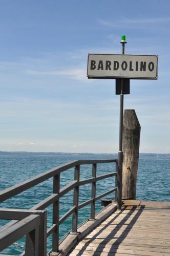 a street sign on a pier next to the ocean at Bardoliners in Bardolino