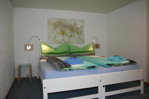 a bed with green and yellow pillows on it at BnB Mönthal im Jurapark in Mönthal 