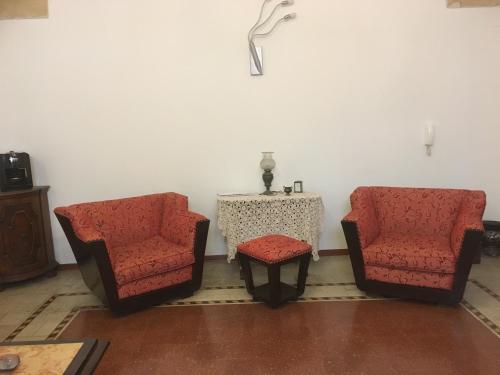two chairs and a table in a room with a tableablishangering at Stelmalu' in Novoli
