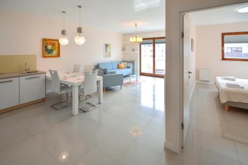een woonkamer met een keuken en een eetkamer bij Osiedle Platan - Apartamenty Bryza - Centrum in Świnoujście