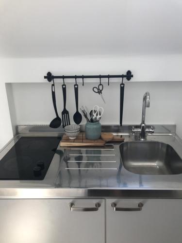 a kitchen with a stainless steel sink and utensils at Koningshof in Alkmaar