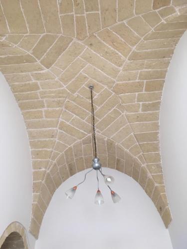 a brick ceiling with aendant light hanging from it at Stelmalu' in Novoli