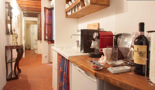 Il Duca Apartment في فلورنسا: مطبخ مع كونتر مع زجاجة من النبيذ