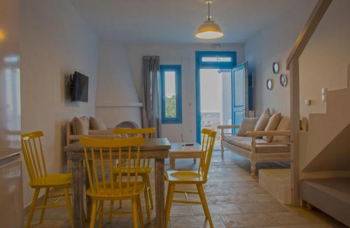 uma sala de jantar com cadeiras amarelas e uma mesa em Almyra Guesthouse em Skiros