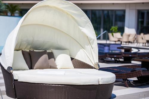 a wicker bed with pillows on a patio at Aura Hotel Adults Only in Balatonfüred