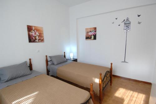 a room with two beds and a lamp on the wall at Salakos Mountain View Home in Sálakos