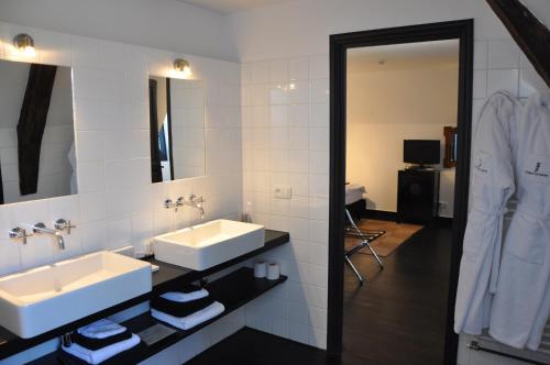 a bathroom with two sinks and a mirror at Château Les Merles et ses Villas in Mouleydier
