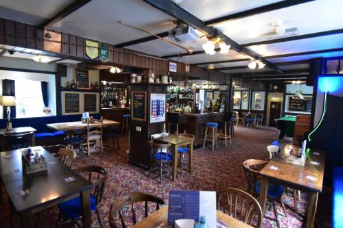 a restaurant with tables and chairs and a bar at The Bugle Inn in St Austell
