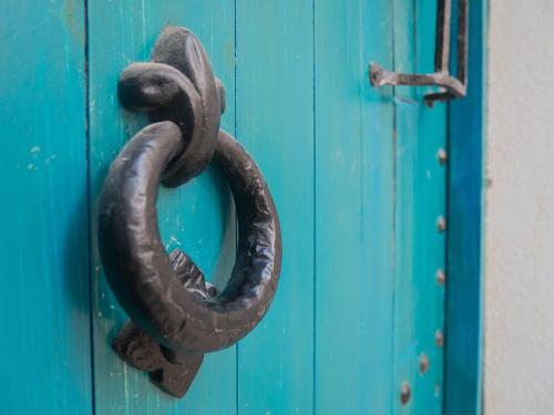 a metal object is hanging on a blue door at Chapel 5 Boutique Suites B&B in Naxxar