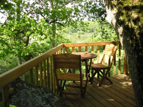 une table et deux chaises sur une terrasse en bois dans l'établissement Cabanes et Studios à la Bernardiere, à Saint-Macaire-en-Mauges
