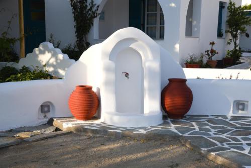 three orange vases sitting next to a white wall at Keti Kapri in Plaka