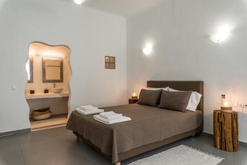 1 dormitorio con cama con espejo y lavamanos en Eleni's Village Suites, en Klouvas