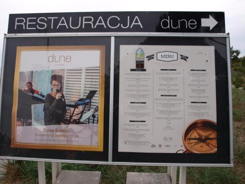 a sign for a restaurant in a beach at Apartament Dune A 004 in Mielno