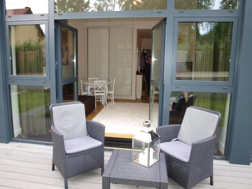 two chairs and a table on a house at Apartament Dune A 004 in Mielno