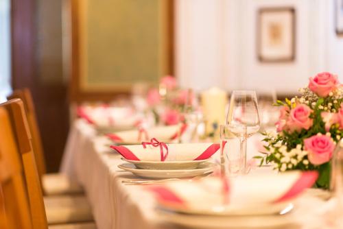 a long table with plates and wine glasses and roses at Hotel Sonnenhof in Schattendorf