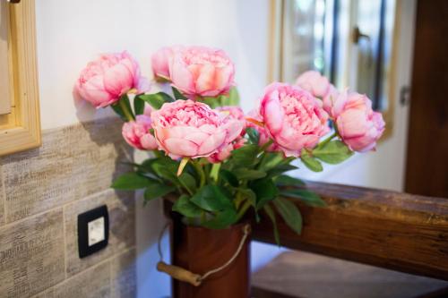 a vase filled with pink flowers on a table at Barn House MM in Bled