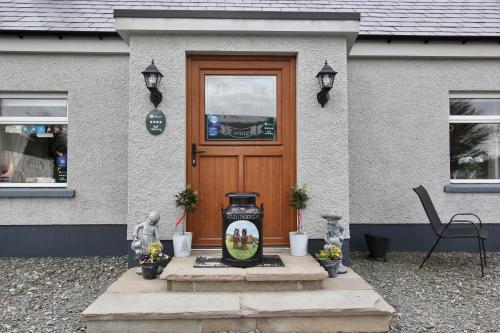 a house with a door with a vase in front of it at Pat Larry's Cottage in Greencastle