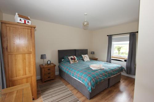 a bedroom with a bed and a window at Pat Larry's Cottage in Greencastle