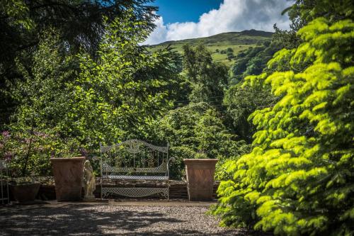 a bench sitting in the middle of a garden at Tir y Coed Country House in Conwy