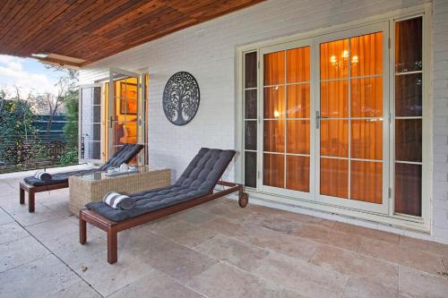 a porch with two lounge chairs on a house at Hahndorf House B&B in Hahndorf