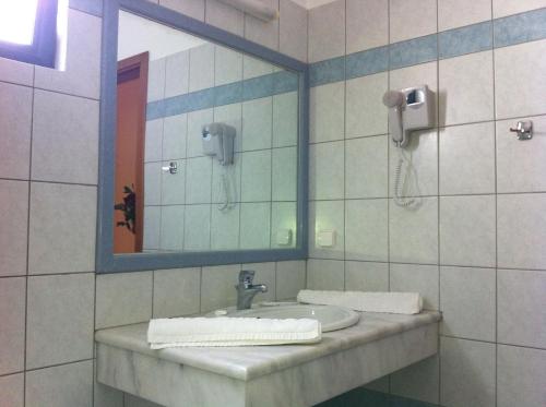 ein Bad mit einem Waschbecken und einem Spiegel in der Unterkunft Angelika Apartotel in Mílatos