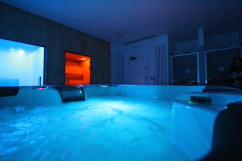 eine große Badewanne mit blauem Wasser in einem Zimmer in der Unterkunft Yarrow Hotel in Broadstairs