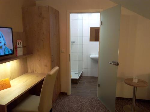 a bathroom with a desk and a sink and a toilet at Hotel Landgasthof Hirsch in Marktlustenau